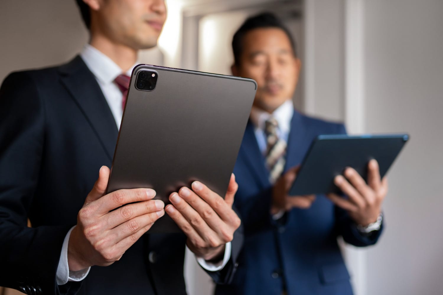 two business men looking at tablets
