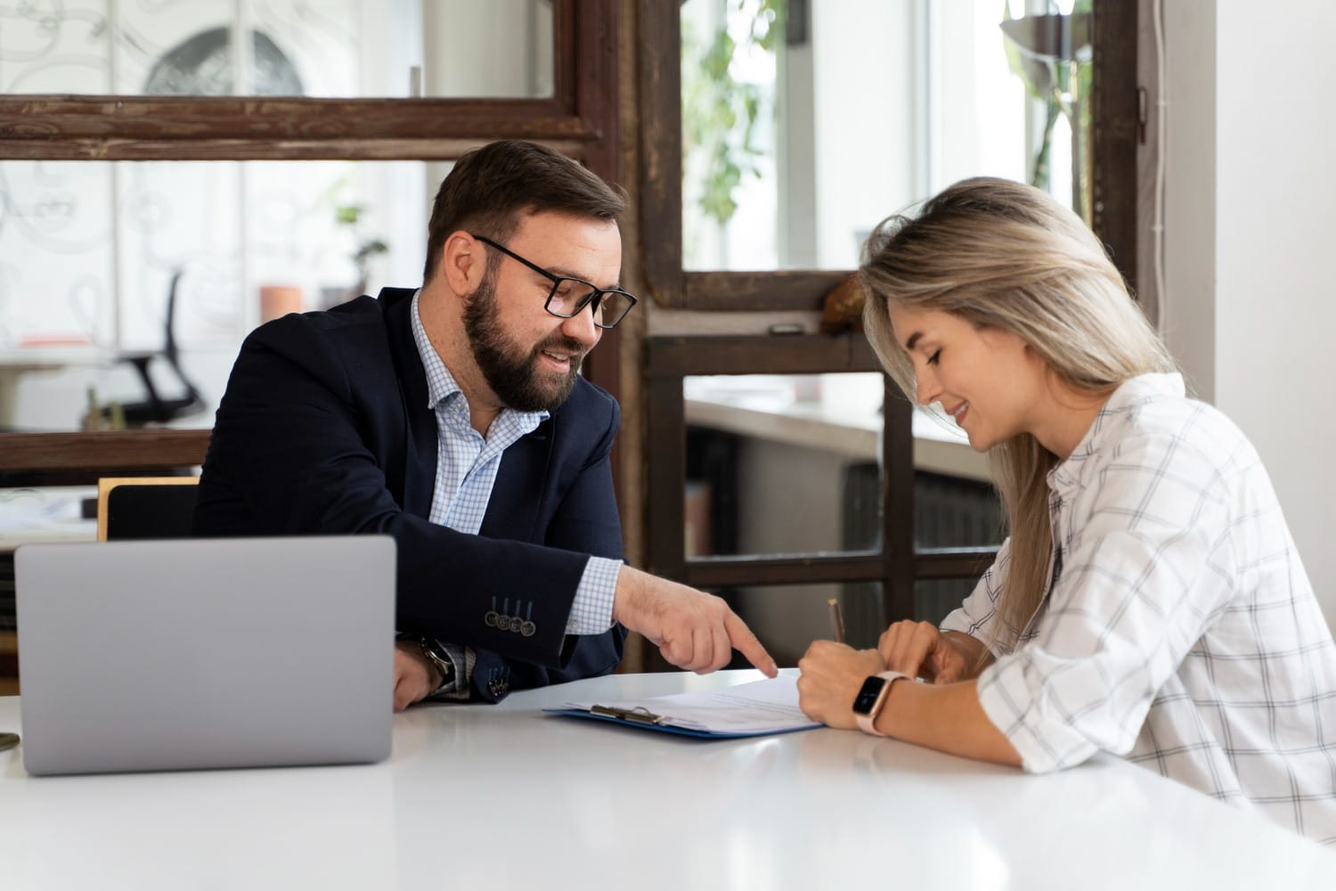 smiling man and woman looking at papers