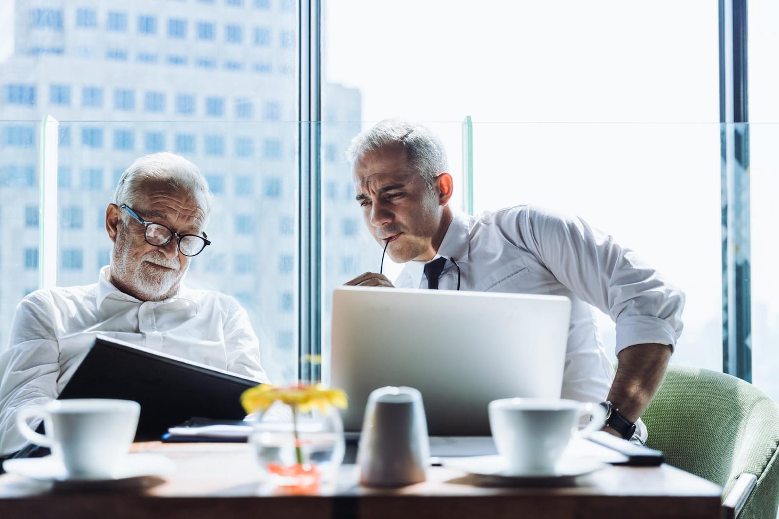 two lawyers looking at a laptop and documents