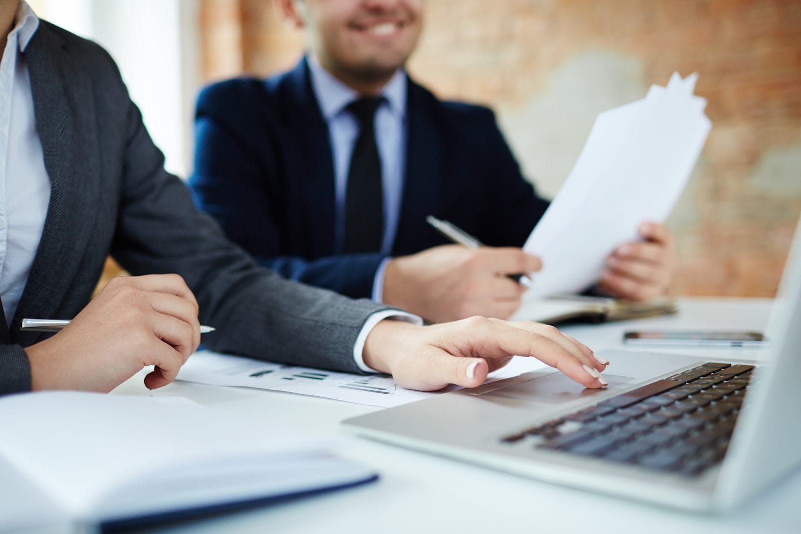 Two businessmen looking at a laptop and documents