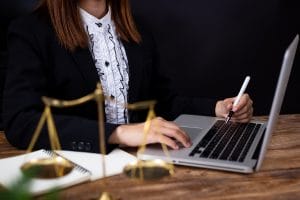 A lawyer using a laptop and pen