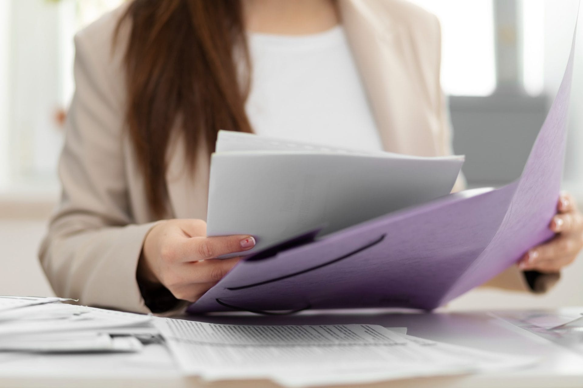A woman holding a folder filled with papers