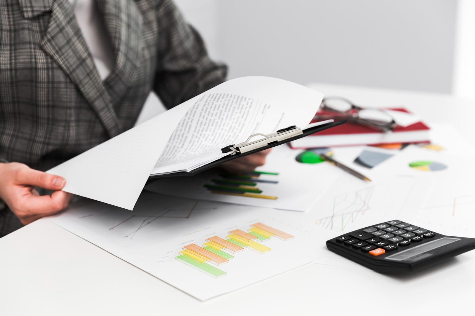 Businesswoman at a table with a clipboard and calculator