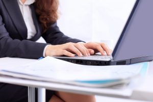 a woman typing on her laptop