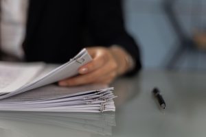 person holding a pile of documents