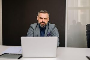 man in a suite using a laptop