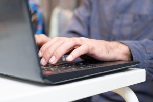 man typing on a laptop